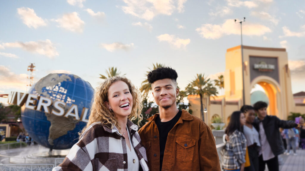 Couple smiling in front of the Universal globe at Universal Studios Florida, home of Rock the Universe