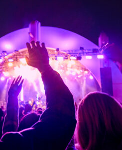 Concertgoers raising their hands in front of a purple-lit stage at Rock the Universe, Universal Studios Florida, Rock the Universe 2027 lineup
