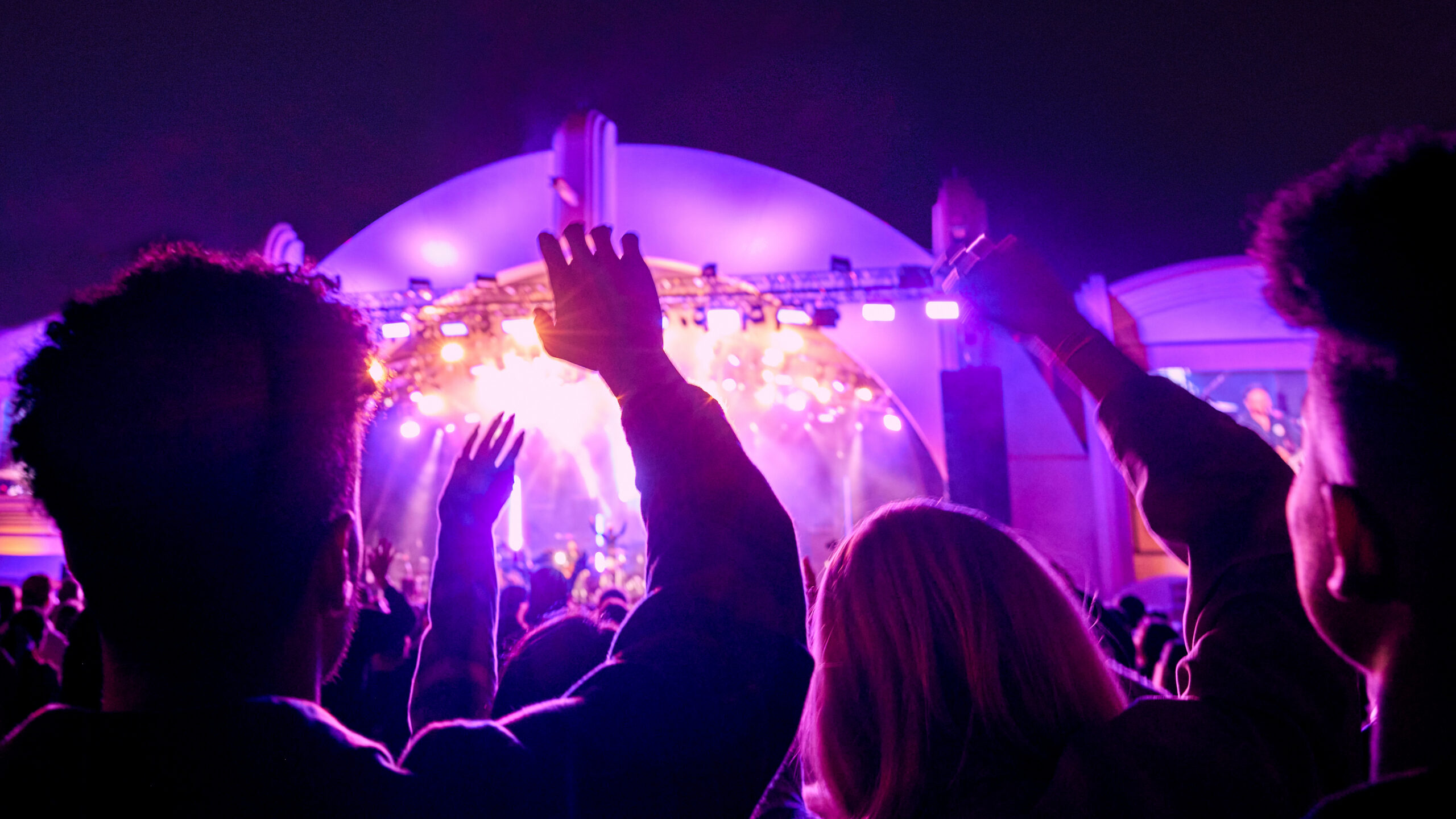 Concertgoers raising their hands in front of a purple-lit stage at Rock the Universe, Universal Studios Florida, Rock the Universe 2027 lineup