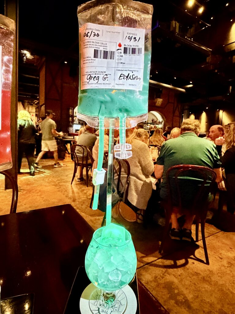 The Franken Fizz Halloween mocktail served from an IV-style bag at The Edison, Disney Springs
