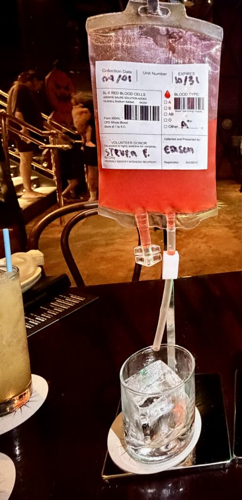 The Blood Donor Halloween cocktail served from a red IV-style bag at The Edison, Disney Springs