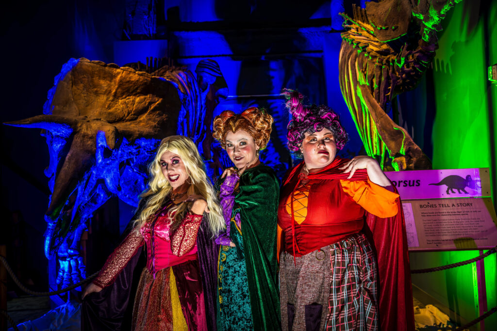 Three guests dressed as witches in DinoDigs at OSC After Dark, Orlando Science Center