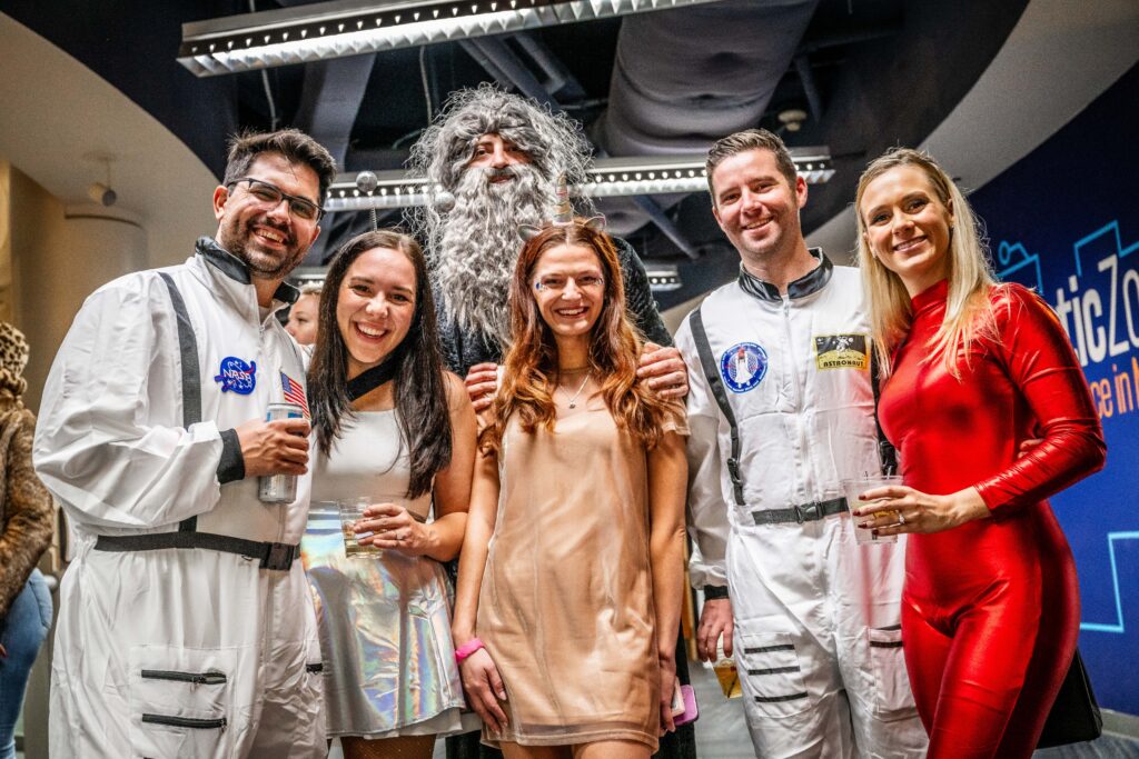 Guests in astronaut and party costumes holding drinks at OSC After Dark, Orlando Science Center